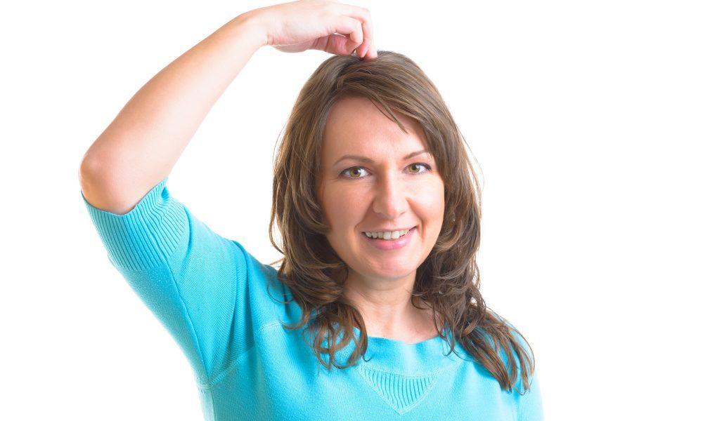 Woman doing EFT on the top head point. Emotional Freedom Techniques, tapping, a form of counseling intervention that draws on various theories of alternative medicine.